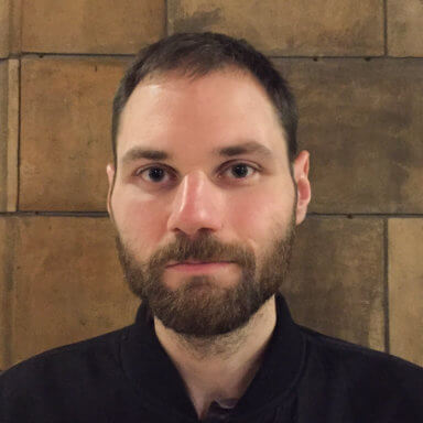 Portrait of the author against a brick background